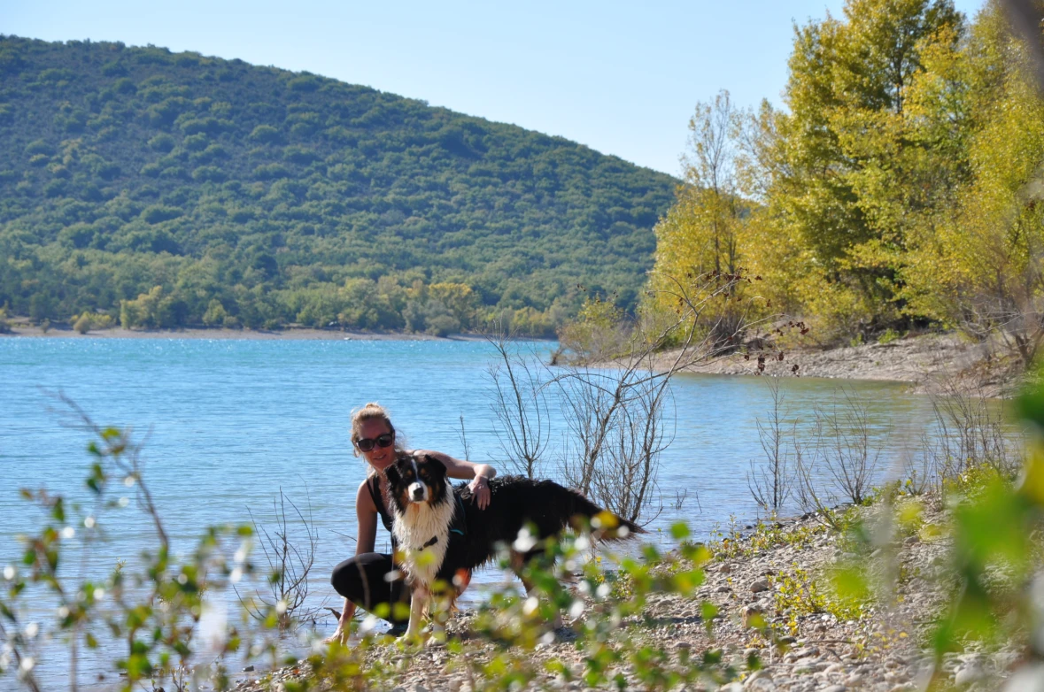 Vanessa qui caresse un chien au bord du lac de Sainte Croix